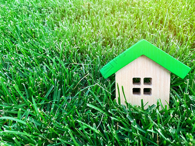 地产围档绿草上的微型木屋房地产概念环保节能的房子在城外买房城市降档自然新鲜空气抵背景