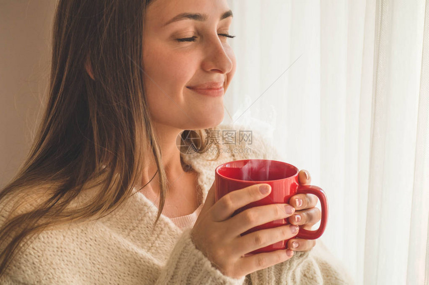 女人在窗边喝杯热饮看着窗外喝茶早上好图片