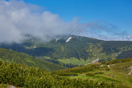山中的夏日风景和乌云密布的深蓝色天空图片