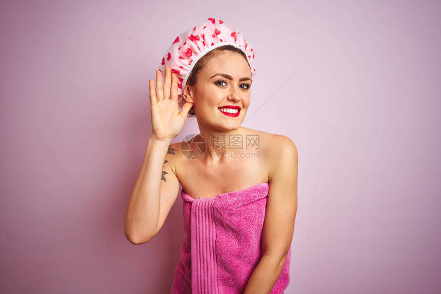 年轻美女在粉红色孤立的背景下洗完澡后图片