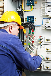 电工建造者在与电流断路器一起工作配电熔断器中电力线路的高压图片