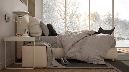 现代白色和灰色简约卧室带枕头和毯子的床镶木地板床头柜和地毯带树木和雪的冬季全景的全景窗背景图片