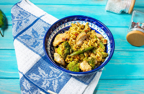鸡肉和蔬菜大米在蓝木制图片