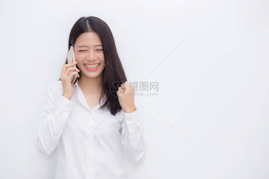 美丽的亚洲年轻女商人兴奋和高兴在水泥背景下成功拿手机图片