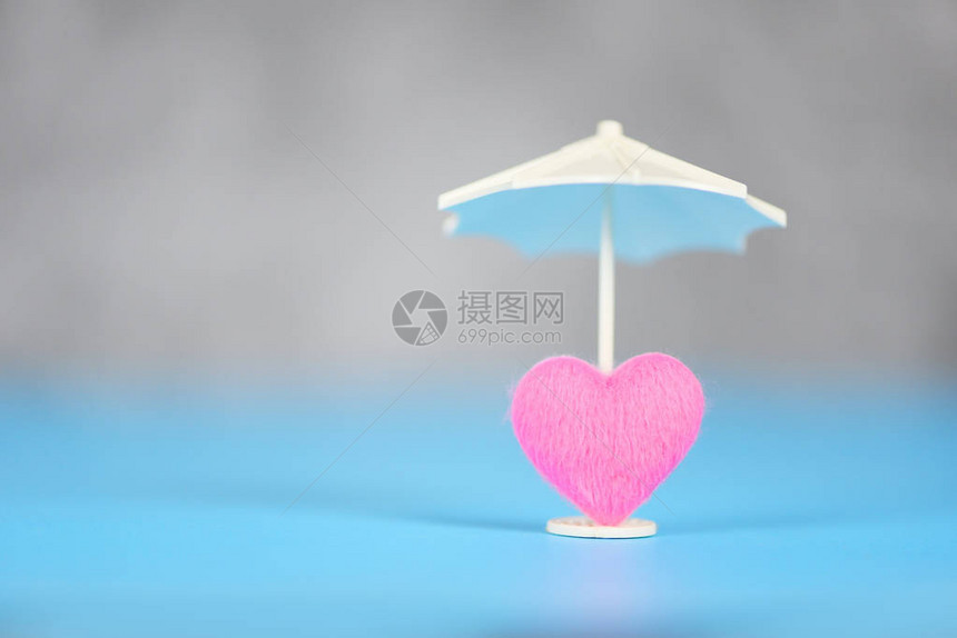 保险健概念蓝色背景粉红心脏护理白伞式图片
