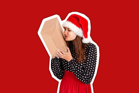 戴着圣诞帽的失望女孩手里拿着一份大礼物具有时尚色彩背景的杂志拼贴风背景图片
