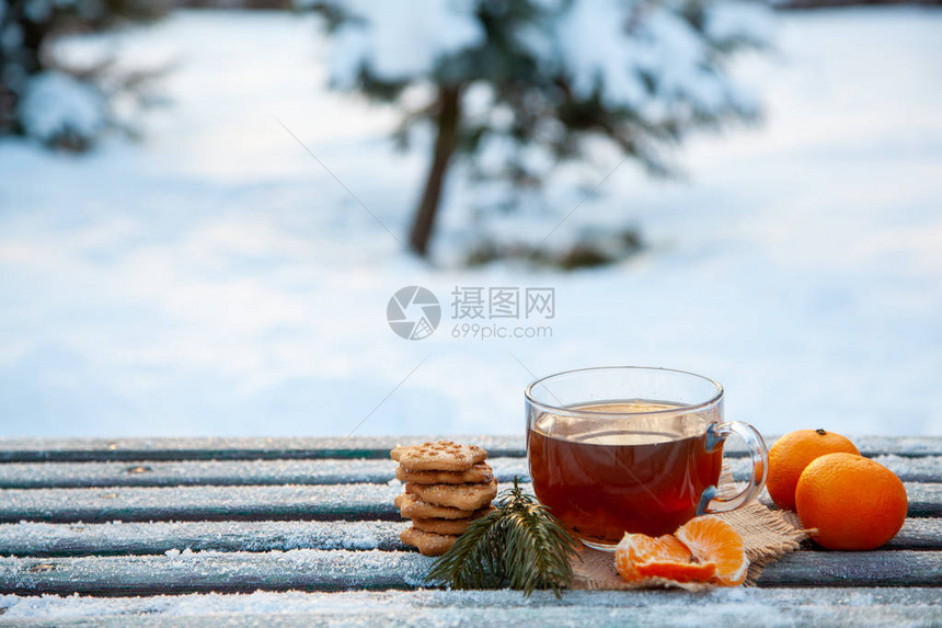 冬季森林里的一杯热茶橘子和饼干圣诞静物的概念复制空图片