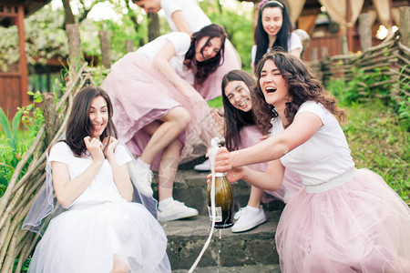 欢快的女孩和年轻的新娘穿着白色T恤和粉红色蓬松的薄纱裙图片
