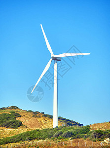 风力涡轮机在干旱地区与蓝色天空背景之间发电图片