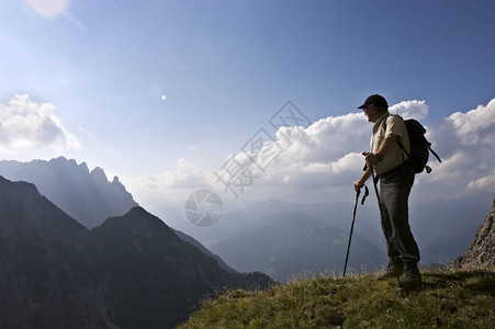 活跃的高级登山者站在顶峰附近图片