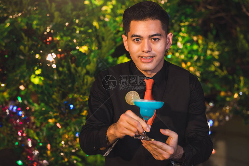 专业调酒师在夜吧俱乐部柜台用冰酒杯准备新鲜的蓝汁鸡尾酒职业和人们的生活方式概念户外图片