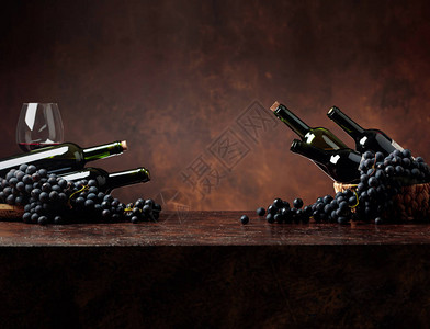 棕色背景的果汁蓝葡萄和红酒瓶子图片