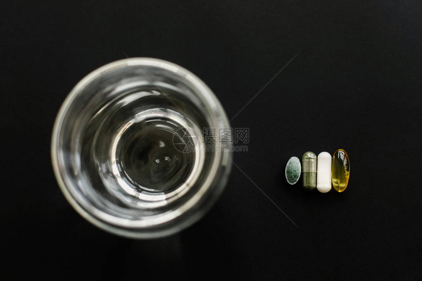 欧米茄3螺旋藻叶绿素黑色深背景勺子上的镁胶囊平躺膳食补充剂每日维生素的剂量健图片