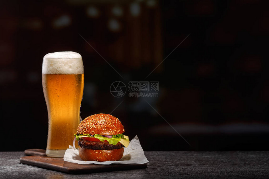 冰霜的轻啤酒杯和汉堡图片
