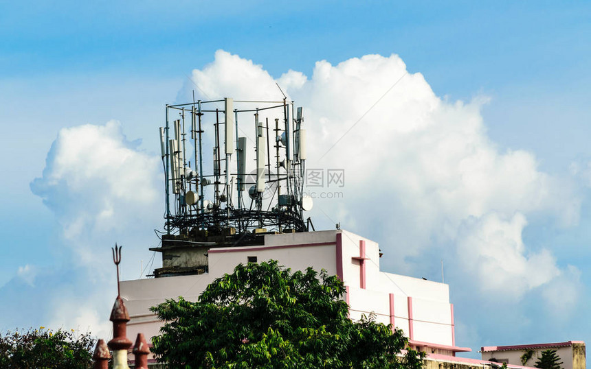 重型高压电力传输蜂窝塔无线电天线广播钢梁塔蜂窝天线工业能源动力设计安装在屋顶建筑物的顶部最小的设计和细节孤立的云天空图片