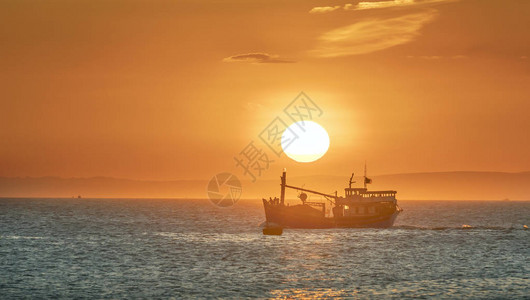 海景日落时渔船出海捕捞鱼到图片