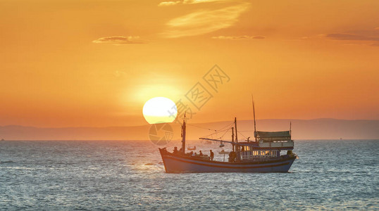 海景日落时渔船出海捕捞鱼到背景图片