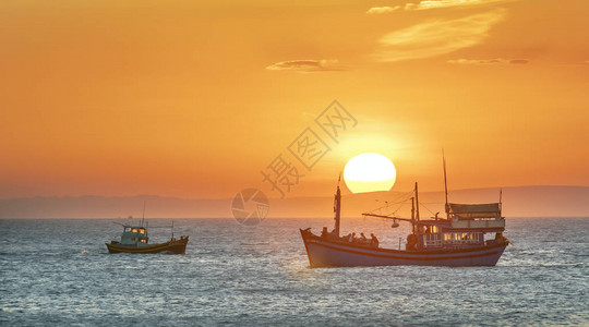 海景日落时渔船出海捕捞鱼到图片
