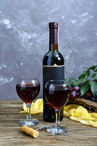 酒杯配红酒瓶子开瓶器蓝葡萄木桌上的叶图片