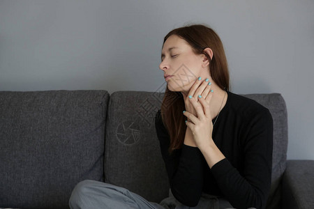 一名年轻妇女喉咙疼痛或甲状腺问题症状的图片