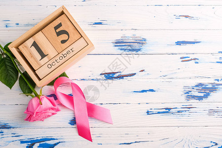 10月15日定在一张木桌上的粉色丝带玫瑰和木图片