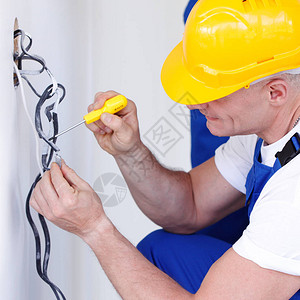 电工剥墙壁插座的电线图片