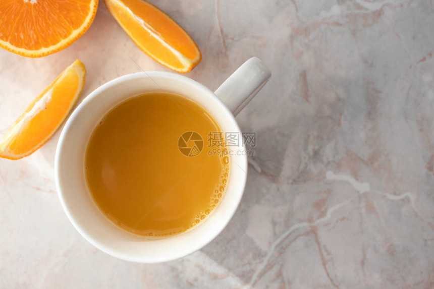 热杯新鲜自制橙汁和切橘子在桌子上Top图片