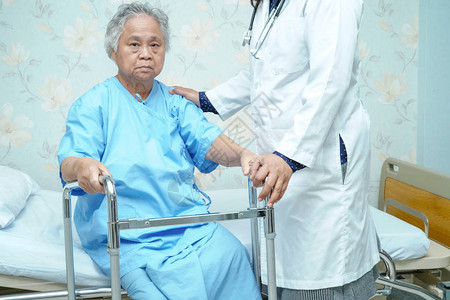 与您同行亚洲老年或老年妇人患者在护理医院病房与步行者同行背景