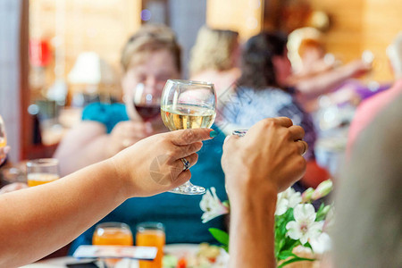 干杯一群人在餐厅喝酒和敬酒手里拿着一杯香槟和酿酒吐司圣诞新年婚礼假期聚会时间庆祝图片