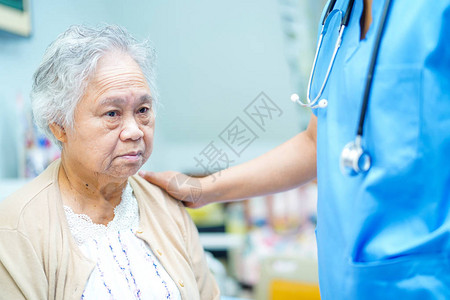 亚洲护士理疗师医生护理帮助和支持老年或老年妇人患者躺在医院病房的床上图片