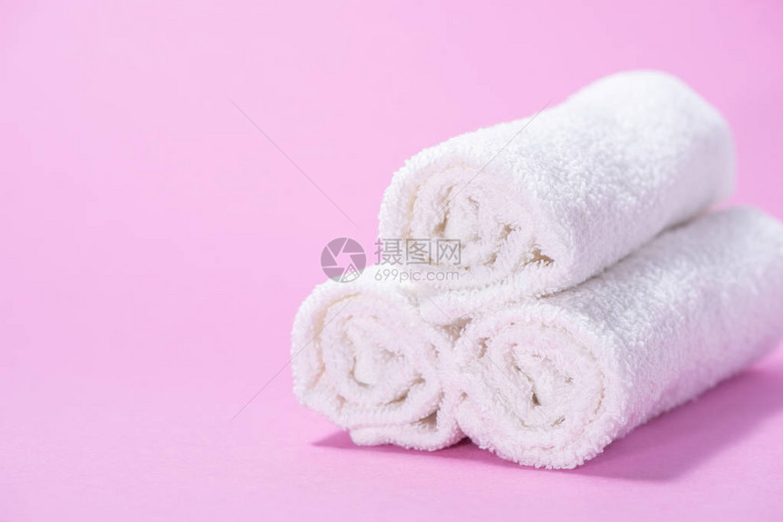 轻滚动软毛巾用于粉红背景图片
