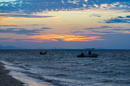大海是蓝色的远处有两艘船日落泰国图片