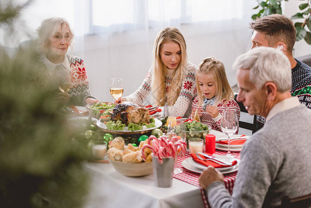家庭成员坐在桌旁庆祝圣诞节图片