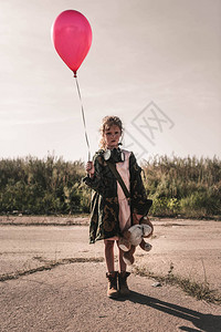 带防毒面具的可爱孩子拿着红色气球后图片