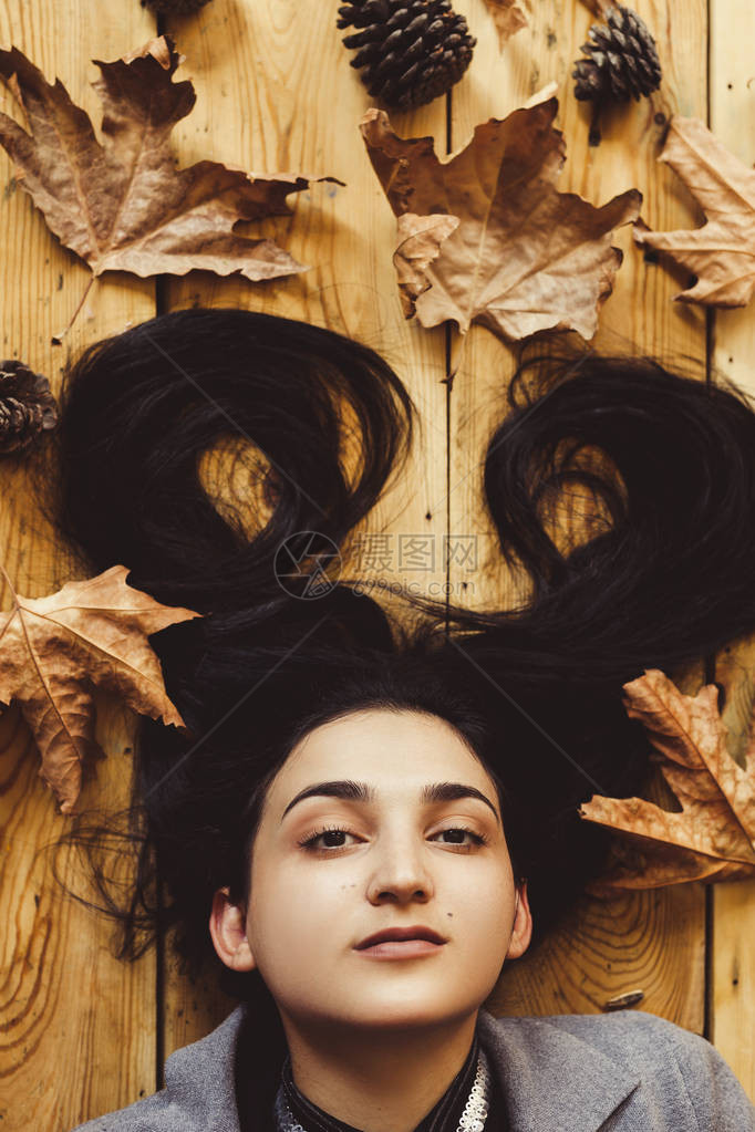 秋天的女人秋季的概念躺在木地板上的女人的肖像年轻美丽快乐的女拿着大黄秋图片
