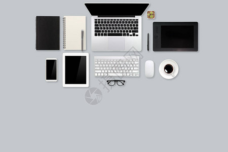 配备膝上型计算机咖啡杯办公室用品和灰色背景移动的现代工作图片