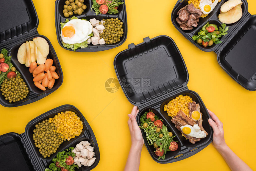 以玉米肉类炒蛋和沙拉为孤立在黄色上的妇女拥有生态包装图片