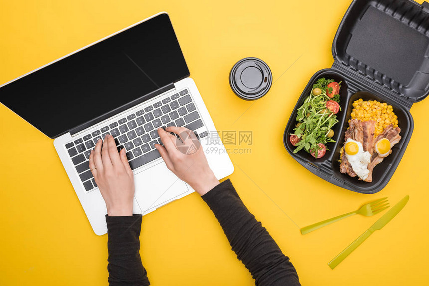 使用手提笔记本电脑和生态包装玉米肉类煎蛋和沙拉黄图片