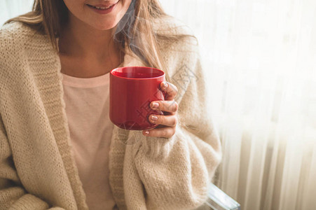 女人在窗边喝杯热饮看着窗外喝茶早上好图片