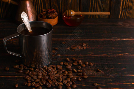 铁杯加黑咖啡蜂蜜和木制桌上的咖啡图片