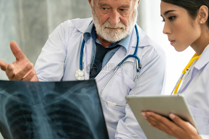 高级男医生在医院与另一位医生合作时查看患者胸部受伤的X光片医疗保健人图片