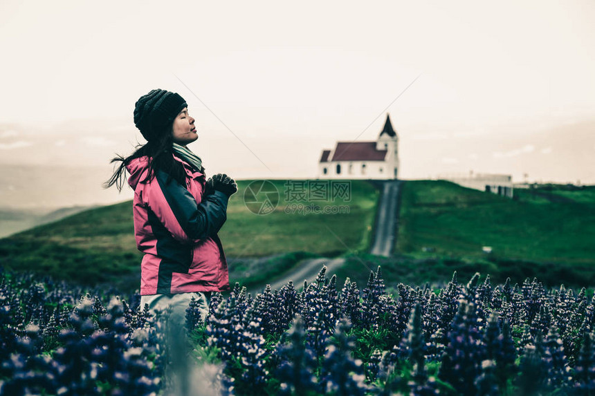 女旅行者前往冰岛赫利桑杜尔的英贾尔德肖尔教堂图片