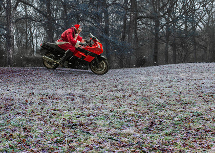 圣诞老人骑着一辆红色的重型摩托车图片