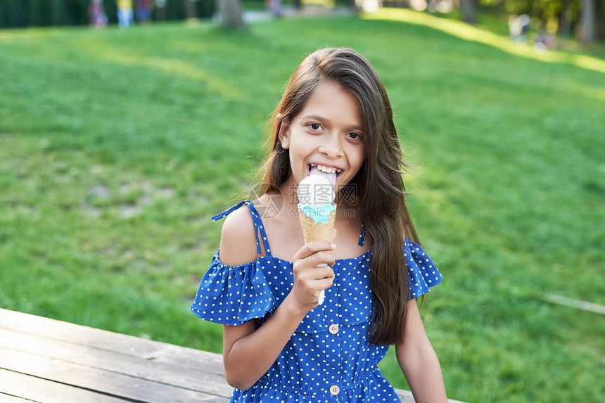 夏日公园里吃冰淇淋的小女孩图片