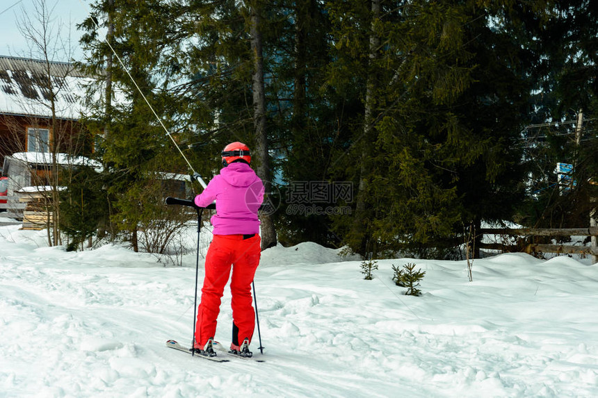 一个女人在滑雪爬上山去滑雪图片