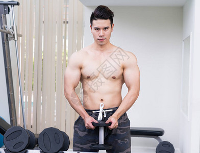 在健身训练中用哑铃锻炼肌肉男健体者图片