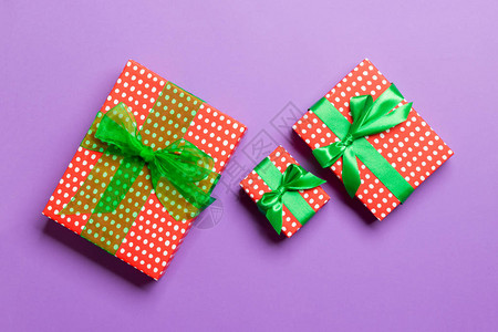 盛装绿弓的礼物盒在圣诞节或新年时手握紫色背图片