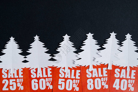 纸上写着圣诞树和红色贴现卡的黑纸什么人圣诞销售概念平背景图片