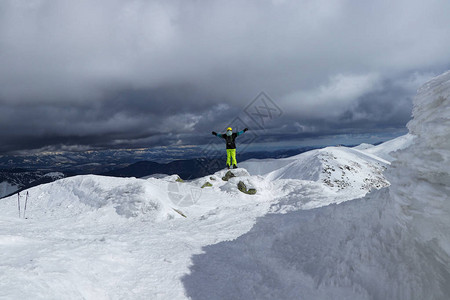 滑雪运动员站在高的悬崖边缘图片