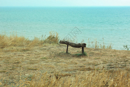 海岸悬崖上的空木凳从上面的海浪的美丽景色孤独的形象图片